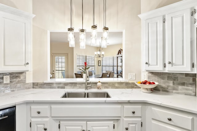 kitchen featuring sink, hanging light fixtures, white cabinetry, and dishwasher