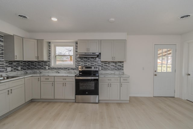 kitchen featuring electric range, gray cabinetry, light hardwood / wood-style flooring, sink, and decorative backsplash