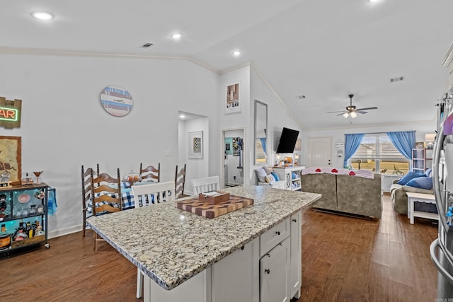 kitchen with white cabinetry, dark wood-type flooring, a center island, and a kitchen breakfast bar