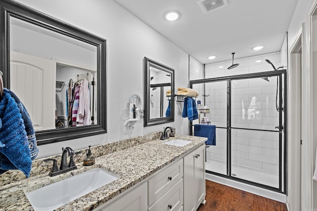 bathroom with vanity, an enclosed shower, and wood-type flooring