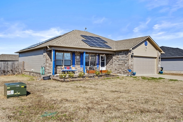 ranch-style house featuring a garage, solar panels, a front yard, and a porch