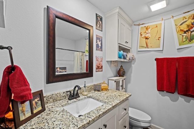 bathroom featuring vanity, a shower with curtain, and toilet