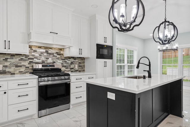 kitchen featuring a center island with sink, black microwave, stainless steel range with gas stovetop, a chandelier, and sink