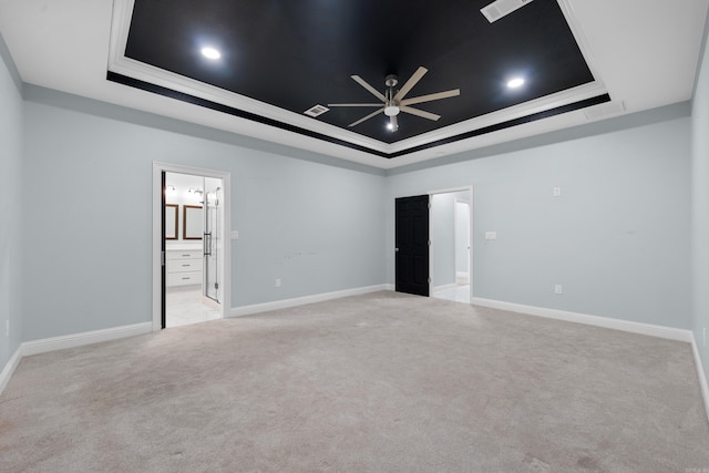 carpeted empty room featuring a tray ceiling, ceiling fan, and ornamental molding