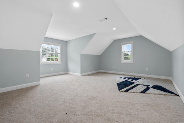 bonus room with light carpet and vaulted ceiling