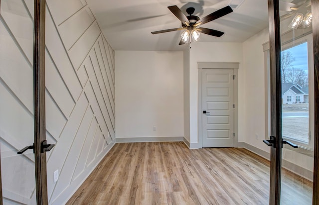 unfurnished room with light wood-type flooring, french doors, and ceiling fan