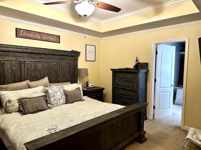 carpeted bedroom featuring a tray ceiling, ornamental molding, and ceiling fan