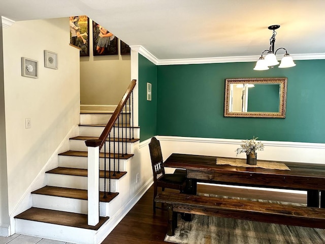 staircase featuring ornamental molding, a chandelier, and wood-type flooring