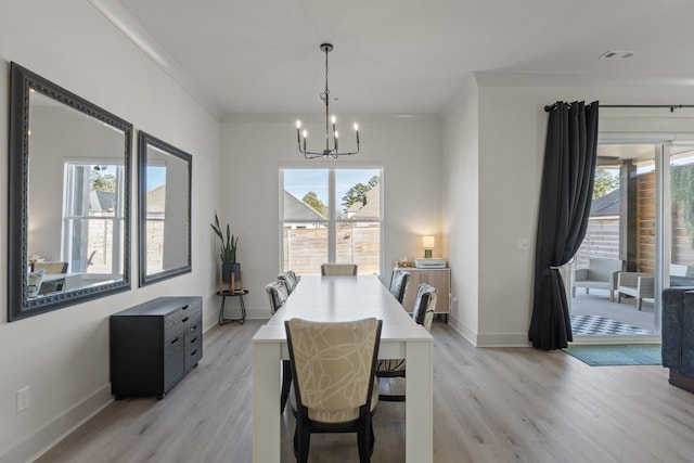 dining area featuring ornamental molding, a chandelier, plenty of natural light, and light hardwood / wood-style floors