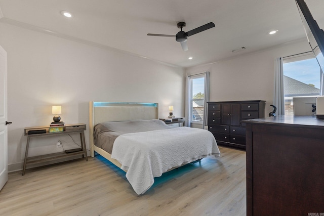 bedroom with ceiling fan, light hardwood / wood-style floors, and multiple windows