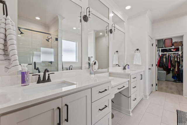 bathroom featuring a shower with shower door, vanity, tile patterned flooring, and crown molding