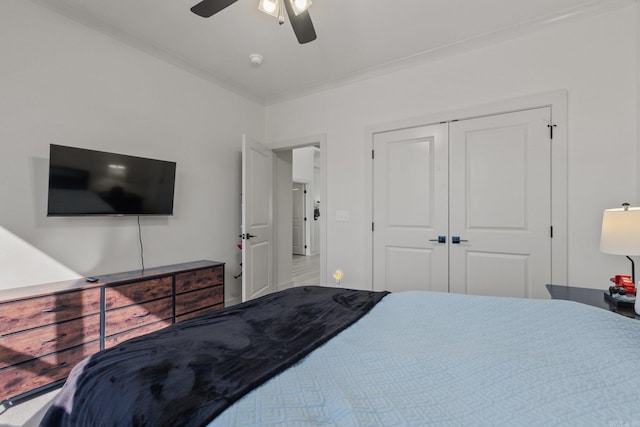 bedroom with a closet, ceiling fan, and ornamental molding