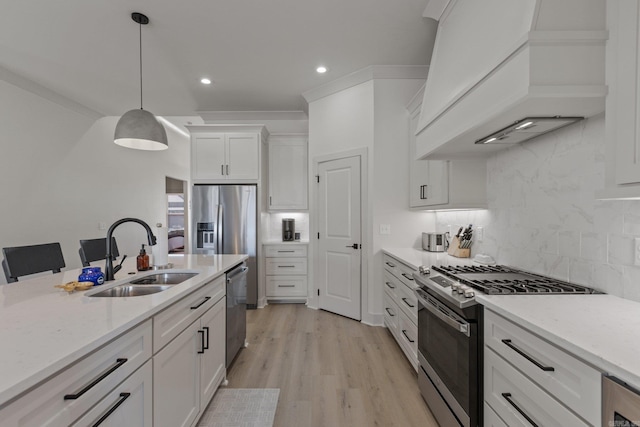 kitchen featuring sink, appliances with stainless steel finishes, white cabinets, and premium range hood