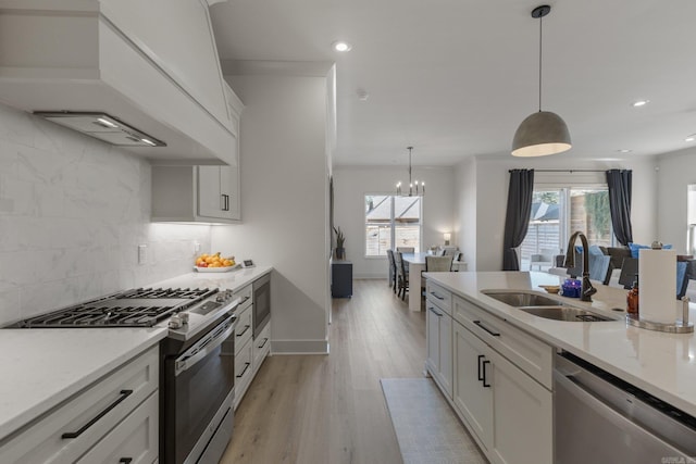 kitchen featuring white cabinetry, custom exhaust hood, sink, and stainless steel appliances