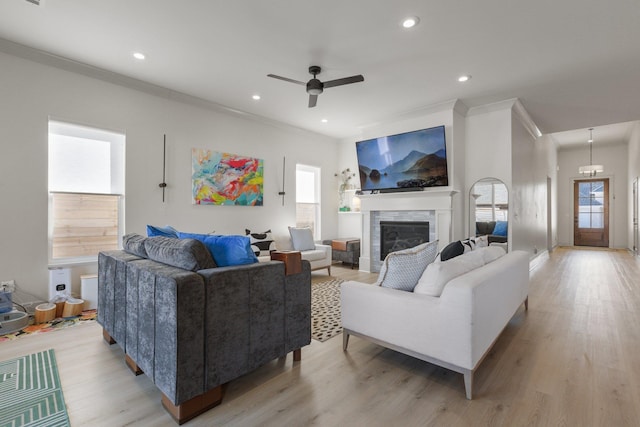 living room featuring ornamental molding, plenty of natural light, and light hardwood / wood-style flooring