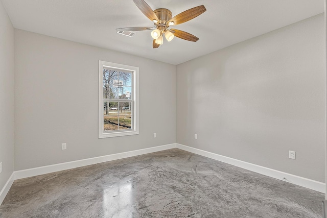 spare room featuring ceiling fan and concrete floors