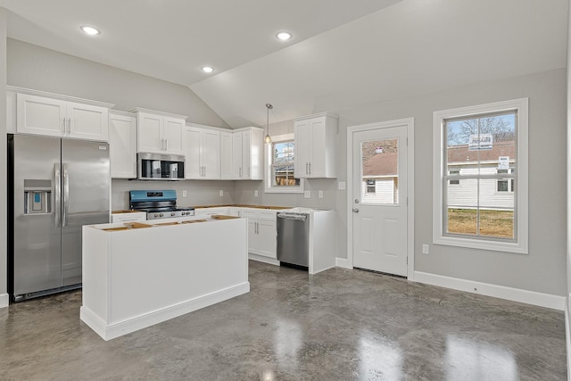 kitchen featuring stainless steel appliances, white cabinetry, and hanging light fixtures