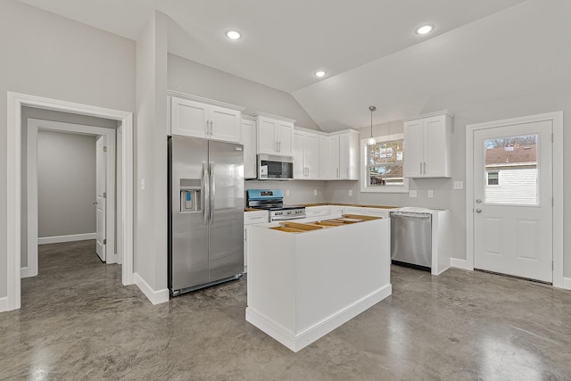 kitchen with stainless steel appliances, hanging light fixtures, white cabinets, and lofted ceiling