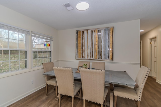 dining area featuring a wealth of natural light and dark hardwood / wood-style flooring