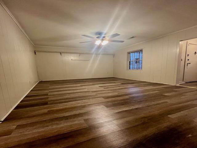 interior space featuring visible vents, dark wood-style flooring, and a ceiling fan