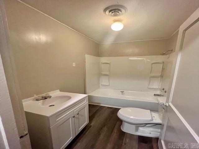 full bath with shower / bath combination, lofted ceiling, toilet, wood finished floors, and vanity