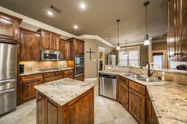 kitchen with stainless steel appliances, light stone counters, decorative light fixtures, a center island, and sink