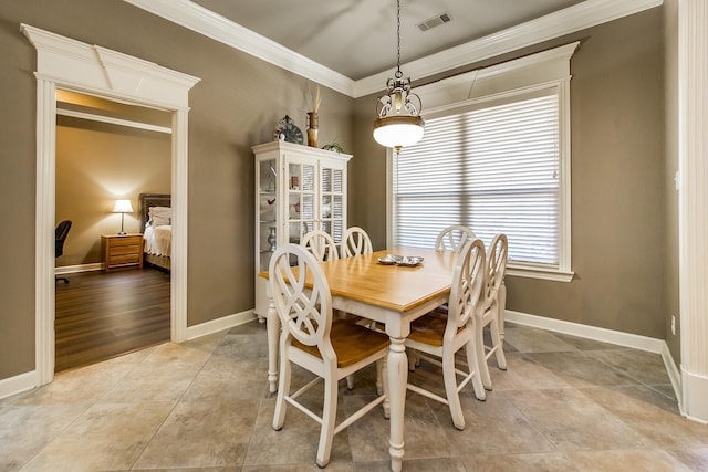 dining area featuring crown molding and light tile patterned floors