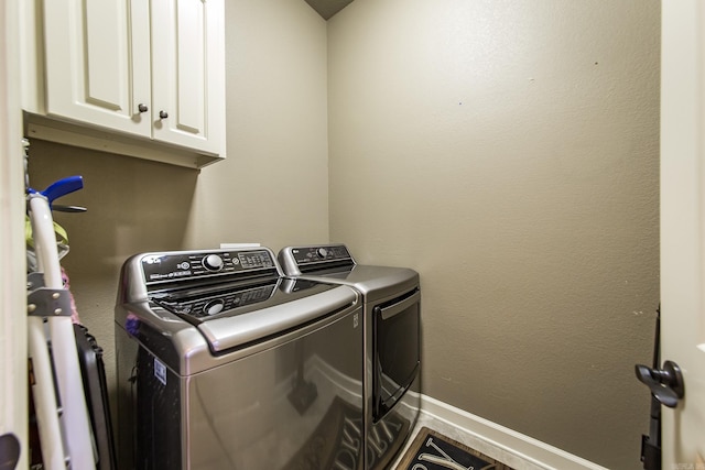 washroom with independent washer and dryer and cabinets