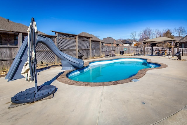 view of swimming pool featuring a patio, a gazebo, and a water slide