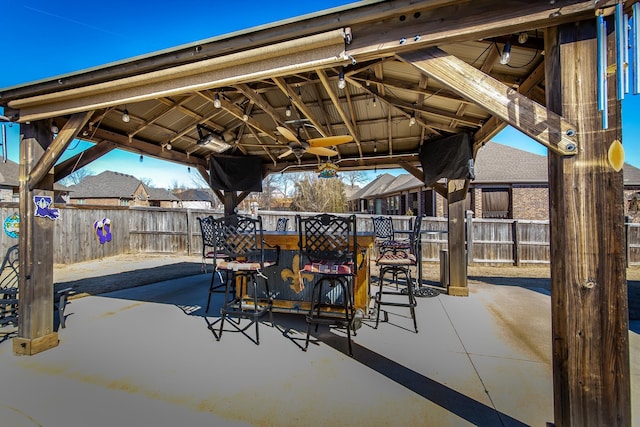 view of patio / terrace with exterior bar, ceiling fan, and a gazebo