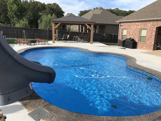 view of swimming pool with a gazebo, a patio area, fence, a fenced in pool, and a water slide