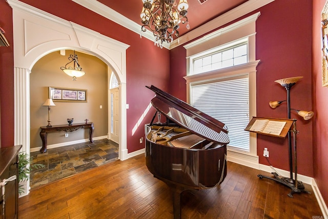 foyer entrance with dark wood-type flooring, a chandelier, and crown molding