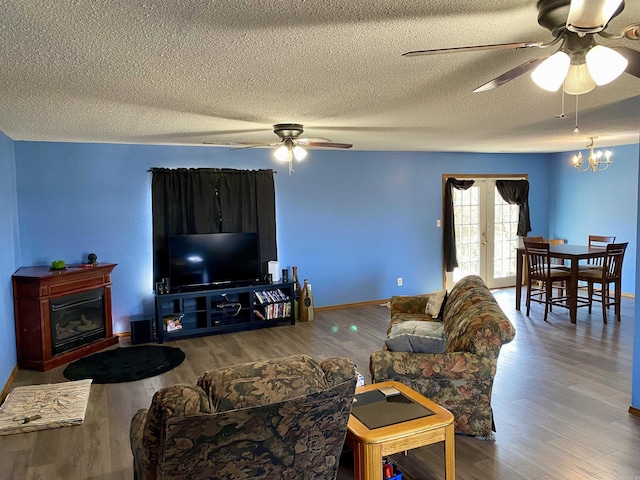 living room featuring hardwood / wood-style flooring, a textured ceiling, french doors, and ceiling fan with notable chandelier