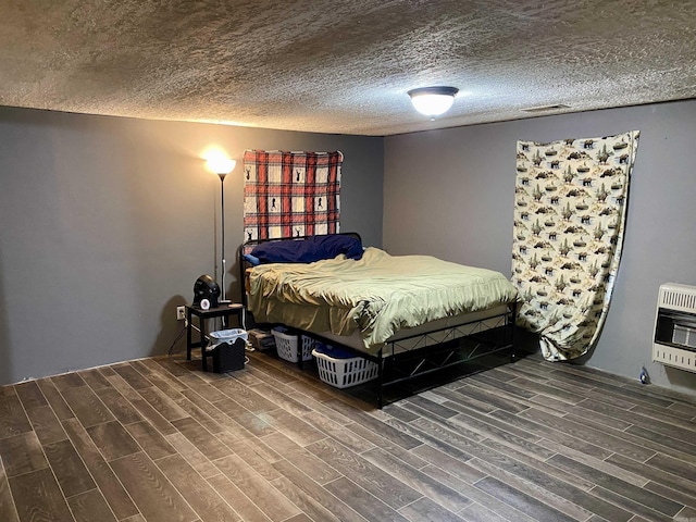 bedroom with heating unit and a textured ceiling