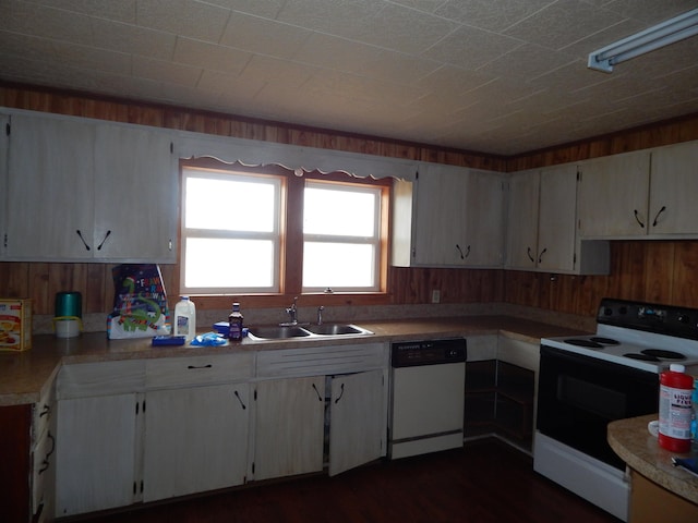 kitchen featuring sink, range with electric cooktop, white dishwasher, dark wood-type flooring, and wooden walls