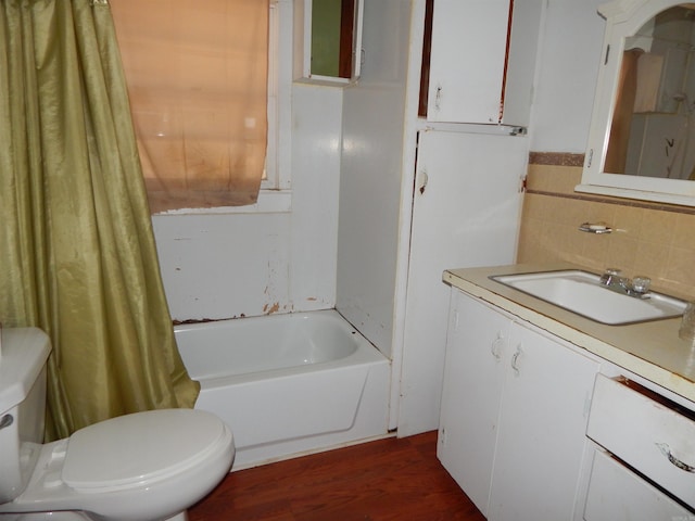 full bathroom with hardwood / wood-style flooring, toilet, tile walls, shower / bath combination with curtain, and vanity