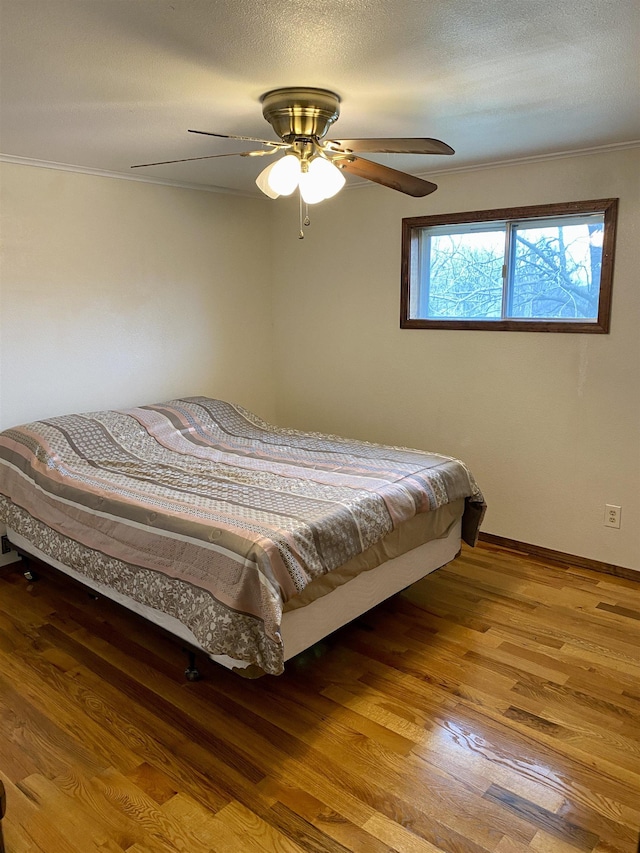 bedroom featuring a textured ceiling, hardwood / wood-style floors, and ceiling fan