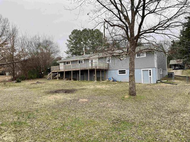 rear view of property featuring a yard and a deck