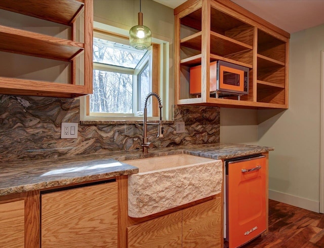 kitchen with sink, stone counters, backsplash, dishwasher, and dark hardwood / wood-style flooring