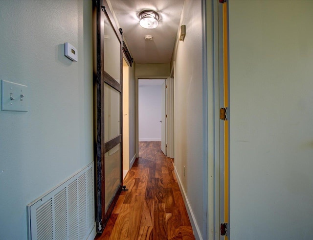 hall with dark hardwood / wood-style flooring and a barn door