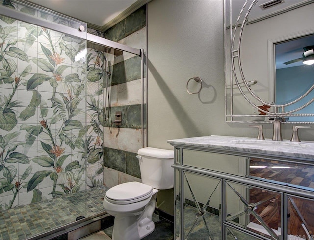 bathroom featuring vanity, a shower with door, and toilet