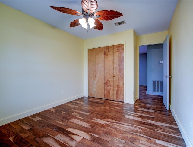 unfurnished bedroom with hardwood / wood-style flooring, ceiling fan, and a closet