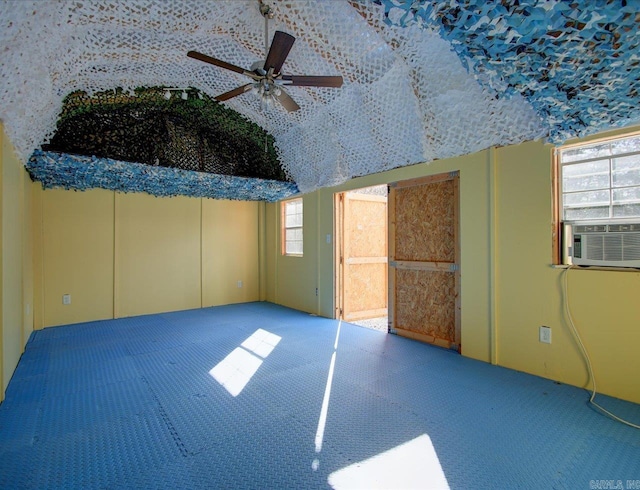 empty room featuring carpet, lofted ceiling, cooling unit, and ceiling fan