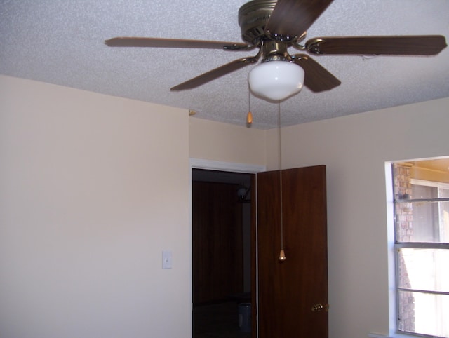 interior space with a ceiling fan and a textured ceiling