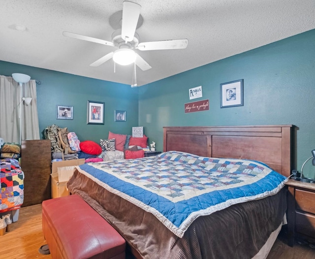 bedroom featuring hardwood / wood-style floors, ceiling fan, and a textured ceiling