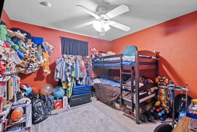 bedroom with ceiling fan, carpet flooring, and a textured ceiling