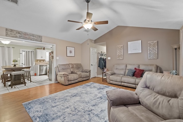 living room featuring ceiling fan, lofted ceiling, and light hardwood / wood-style floors