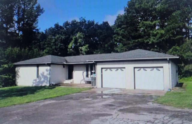 ranch-style house featuring a garage and a front lawn