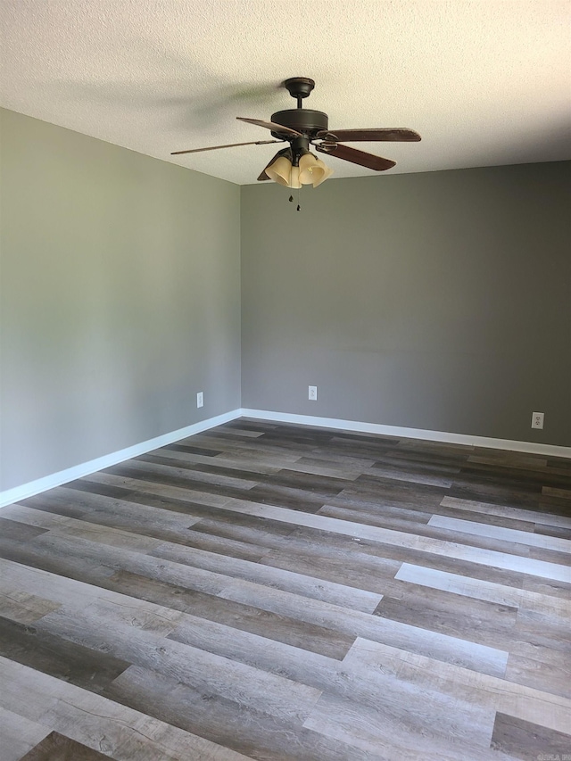 empty room featuring dark hardwood / wood-style flooring, ceiling fan, and a textured ceiling