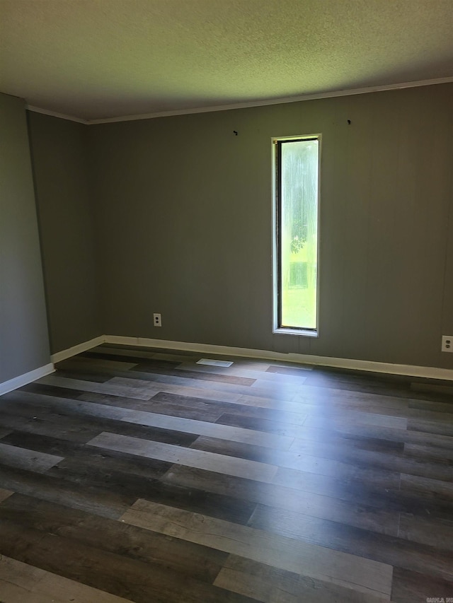 spare room featuring a textured ceiling, dark hardwood / wood-style floors, and ornamental molding